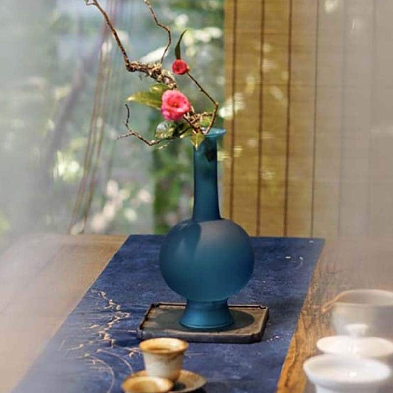 This is a blue glass vase flower arrangement vessel