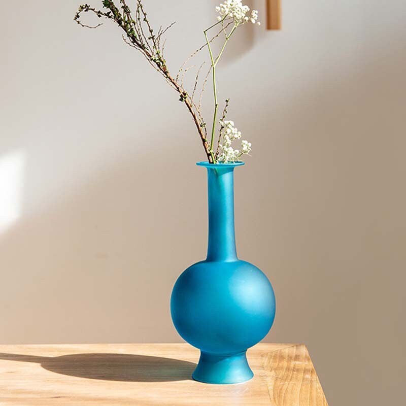 This is a blue glass vase flower arrangement vessel