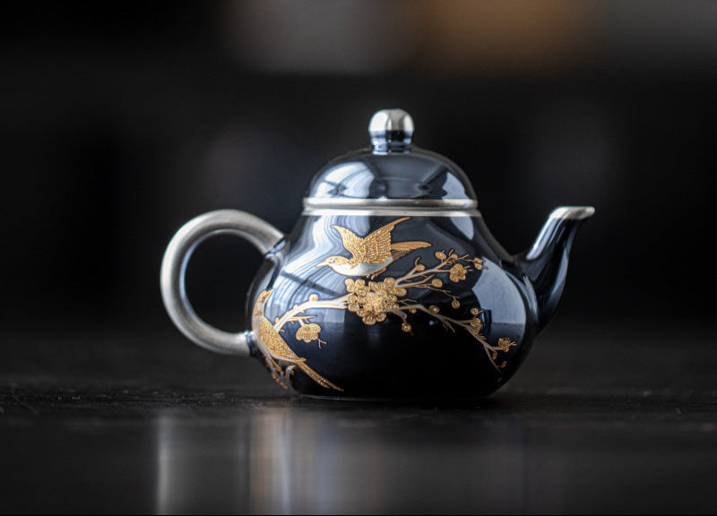 this is a ceramic teapot. this is a gilded silver teapot