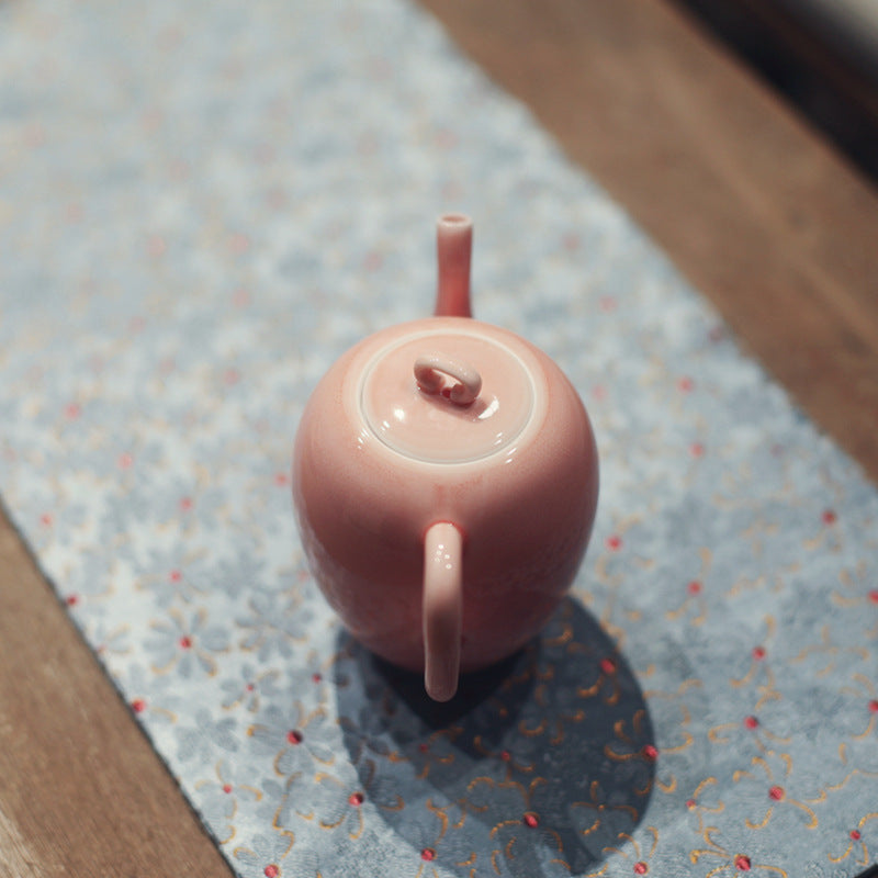 this is a pink ceramic teapot