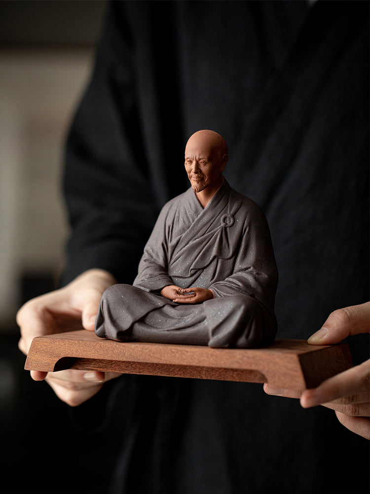 this is a mini pottery monk sculpture