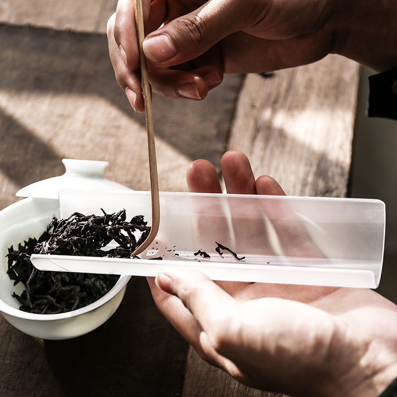 This is a glass tea scoop