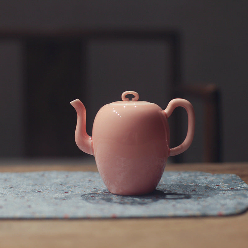 this is a pink ceramic teapot