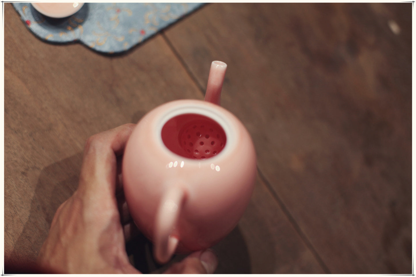 this is a pink ceramic teapot