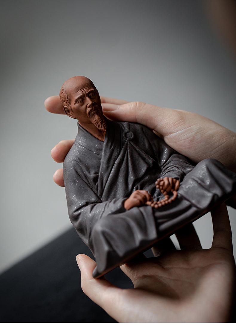 this is a mini pottery monk sculpture