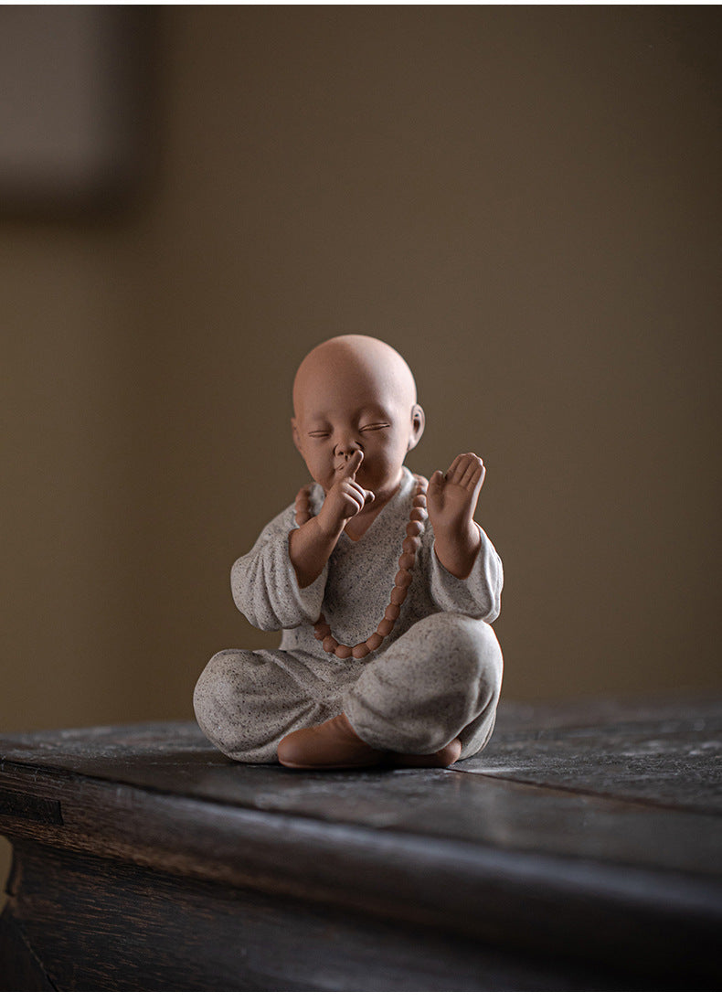 this is a mini pottery monk sculpture