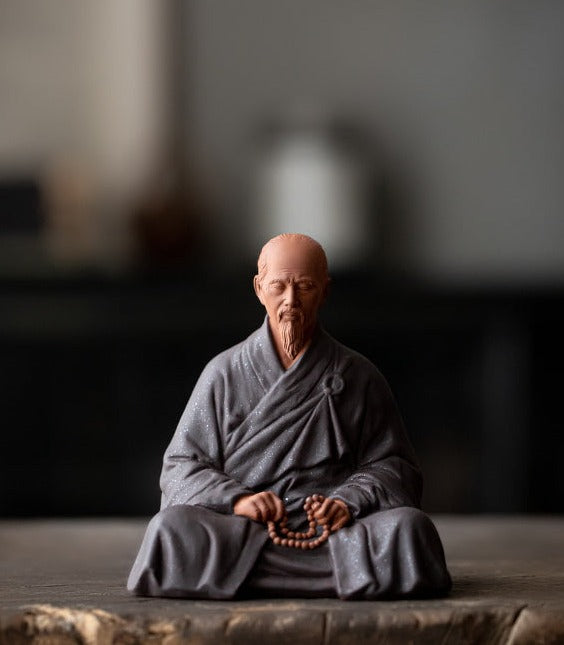 this is a mini pottery monk sculpture