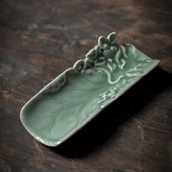 This is a green celadon ceramic tea scoop