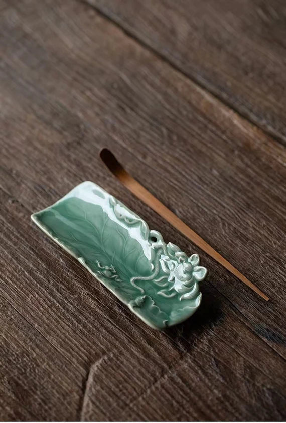 This is a green celadon ceramic tea scoop