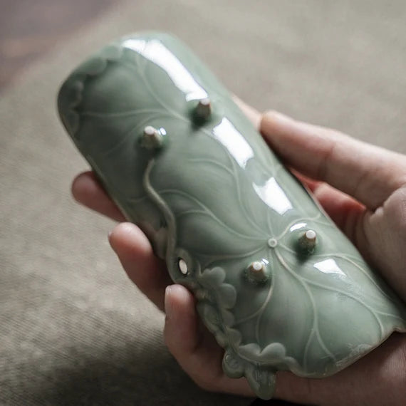 This is a green celadon ceramic tea scoop