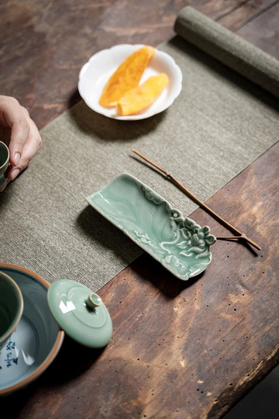 This is a green celadon ceramic tea scoop