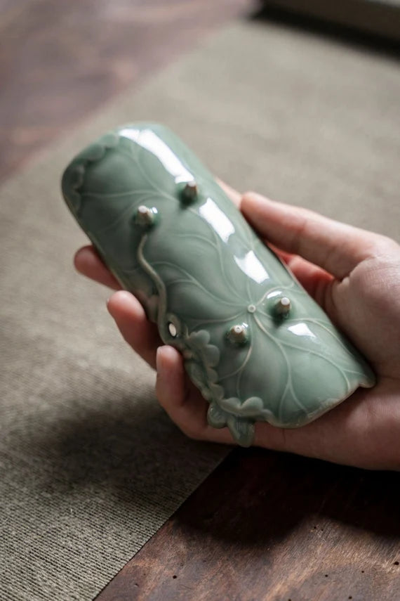 This is a green celadon ceramic tea scoop