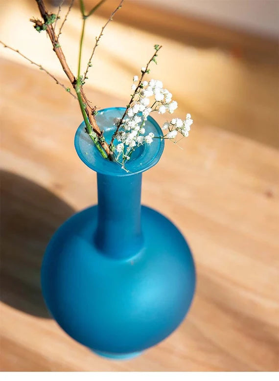 This is a blue glass vase flower arrangement vessel 