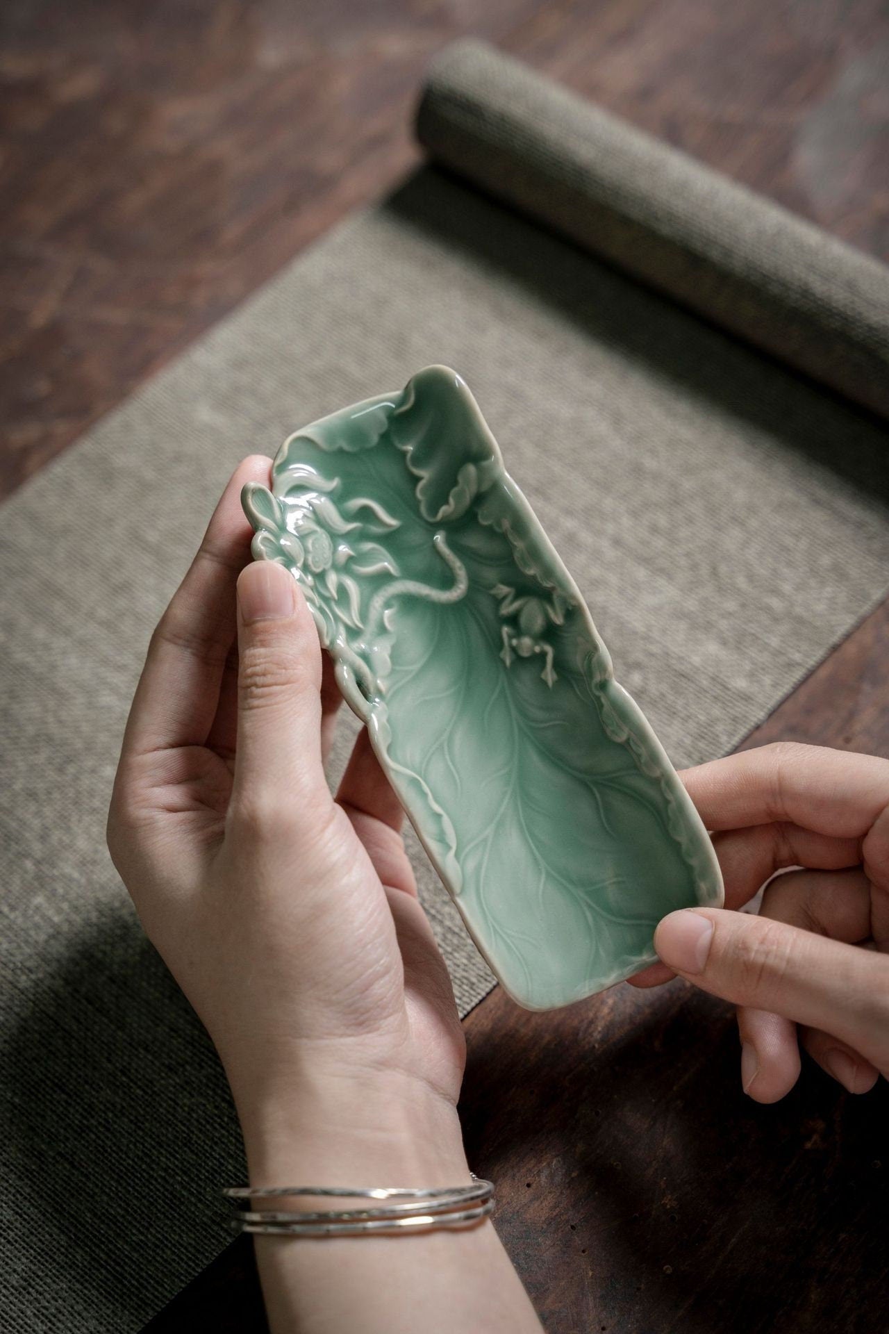 This is a green celadon ceramic tea scoop