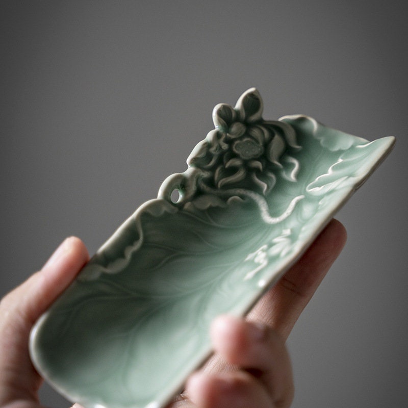 This is a green celadon ceramic tea scoop