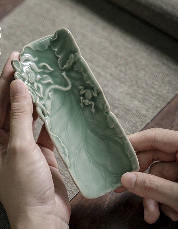 This is a green celadon ceramic tea scoop