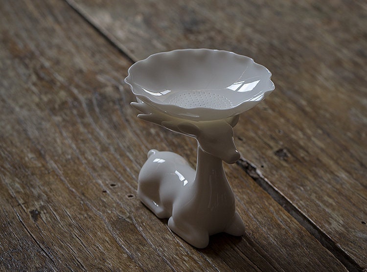 This is a white ceramic tea filter tea funnel