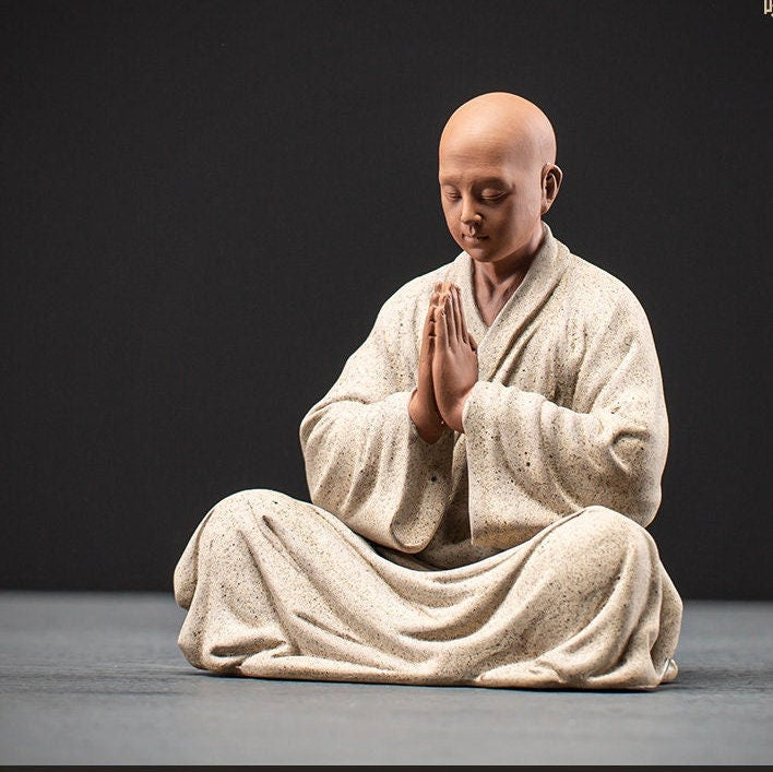 this is a mini pottery monk sculpture