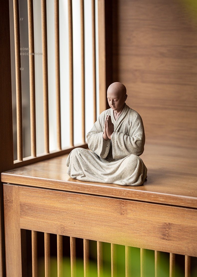 this is a mini pottery monk sculpture