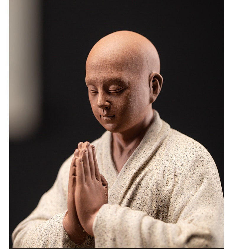 this is a mini pottery monk sculpture