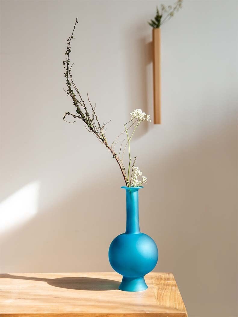 This is a blue glass vase flower arrangement vessel 