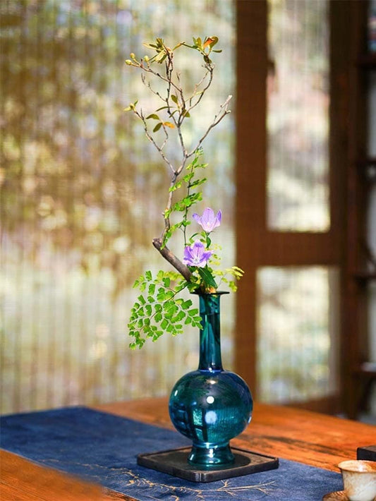 This is a blue glass vase flower arrangement vessel 